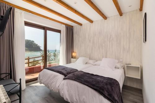 um quarto com uma cama grande e uma janela grande em Hotel SanMar em Cóbreces