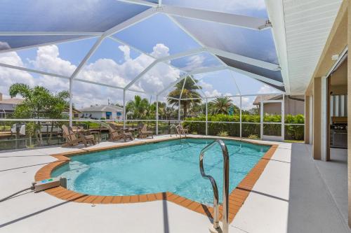 an indoor swimming pool with a glass ceiling at Gulf Access, Heated Pool, Bikes, Kayaks - Comfort on the H2O - Cape Coral - Roelens Vacations in Cape Coral