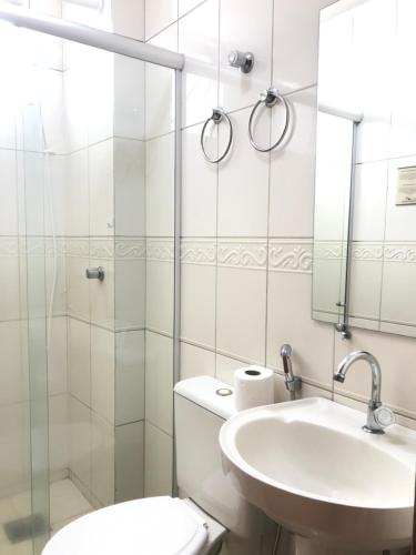 a bathroom with a toilet and a sink and a mirror at Pousada Sossego da Pampulha in Belo Horizonte