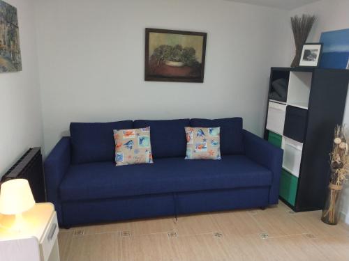 un divano blu con due cuscini in soggiorno di Estudio Guayaba cerca a la playa! a El Puerto de Santa María