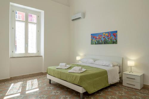 a white bedroom with a bed and a window at Le Case di Franca in Trapani