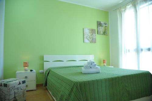 a bedroom with a bed with a green bedspread at B&B Erminia in Presicce