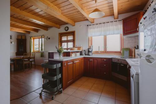a large kitchen with wooden cabinets and a large window at Widokówka Kaszuby in Mirachowo