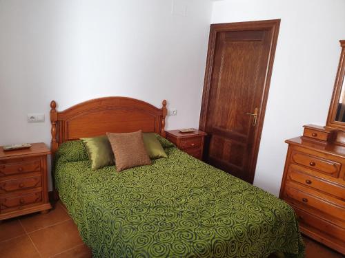 una camera da letto con un letto con un piumone verde di Alojamiento Rural Mirador del Valle a Baños de la Encina
