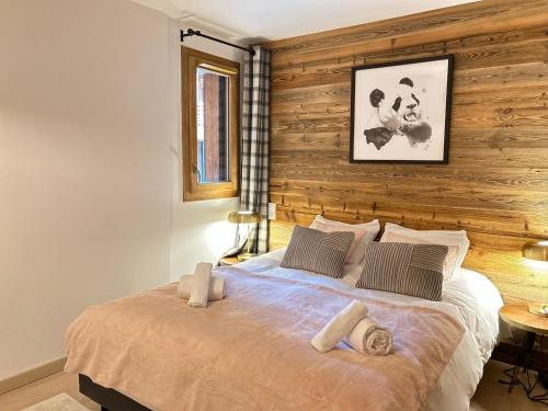 - une chambre avec un lit et un mur en bois dans l'établissement Appartement 4 Chambres au Coeur des Gets - Haut Standing, Parking, Wifi, Balcon, Proche Commerces - FR-1-623-319, aux Gets