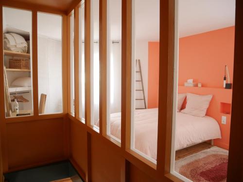 Habitación con paredes de color naranja, cama y escalera. en Le Clos des Confidences en Grignan