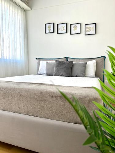 a bedroom with a large bed with four pictures on the wall at Modern Studio near Lugano's Lake & City Center in Lugano