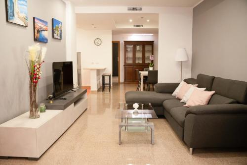 a living room with a couch and a tv at LE FONTI - CHARMING APARTMENT - PUGLIA INN HOLIDAY in Acquaviva delle Fonti