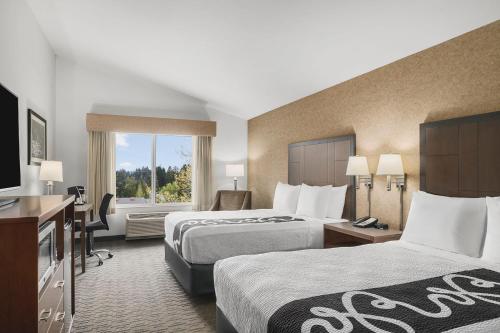 a hotel room with two beds and a television at The INN at Gig Harbor in Gig Harbor