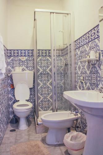 a bathroom with a toilet and a sink at Hotel Solar da Charneca in Leiria
