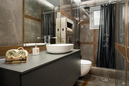 a bathroom with a sink and a toilet at Nefeli Luxury Residence in Marathias