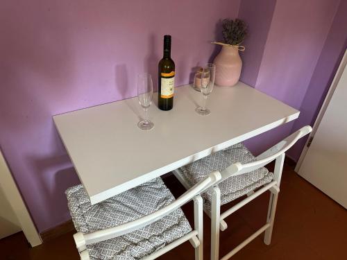 a white table with two glasses and a bottle of wine at Lavanderin Apartment in Dekani