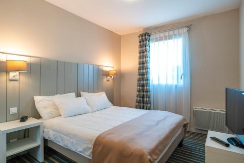 una camera d'albergo con letto e TV di Les Thermes 508 - Appt avec piscine partagée a Concarneau