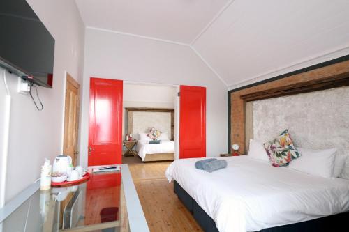 a bedroom with a large bed with red accents at THE PLACE Muizenberg in Muizenberg