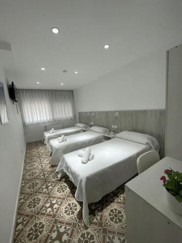 a room with three beds in a room at Hostal Nova Barcelona in Barcelona