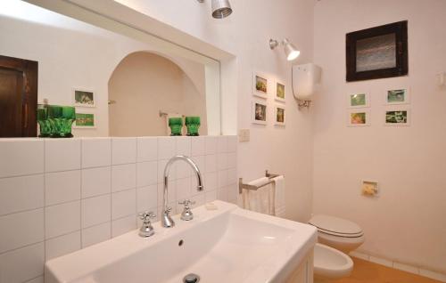 a white bathroom with a sink and a toilet at Castello del Calcione in Lucignano