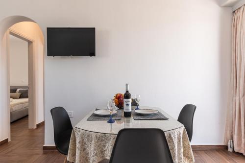 jadalnia ze stołem, krzesłami i telewizorem w obiekcie Naxian White House In Glinado w mieście Glinado Naxos