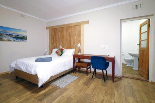 a bedroom with a bed and a desk and a sink at THE PLACE Muizenberg in Muizenberg