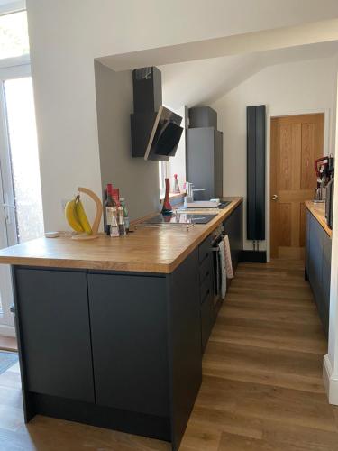 een keuken met een groot eiland met een houten aanrecht bij Comfortable 2 bedroom home from home with parking in Nottingham