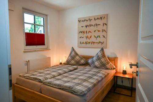 ein Schlafzimmer mit einem Bett mit zwei Kissen und einem Fenster in der Unterkunft Zum Klabautermann in Bresewitz