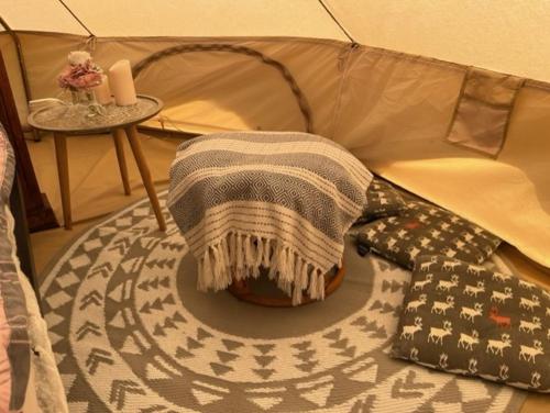 Belinda Bell Tent في بولتون لي فايلد: بطانية وربطة على طاولة في خيمة
