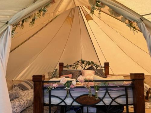 a tent with a bed and flowers in it at Belinda Bell Tent in Poulton le Fylde