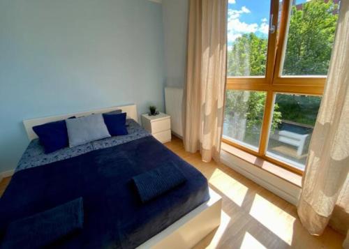 a bedroom with a bed and a large window at Aprt Toruńska / center in Gdańsk