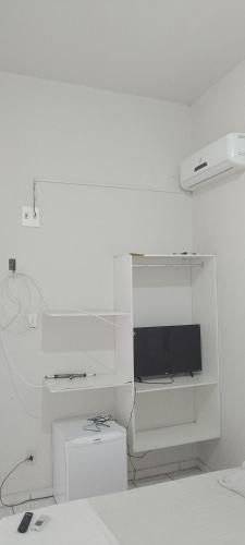a white room with a desk with a monitor and a computer at San Luis in São Luís