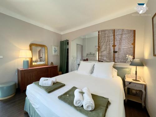 une chambre avec un grand lit blanc avec des serviettes dessus dans l'établissement Villa Pura Vida, à Sainte-Maxime