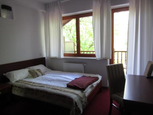 a small bed in a room with a window at Willa M cisza w centrum miasta in Krynica Zdrój