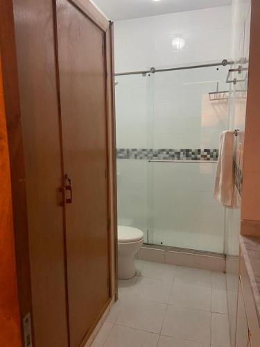 a bathroom with a toilet and a glass shower door at Apartamento Valledupar, exclusivo, cómodo y residencial in Valledupar