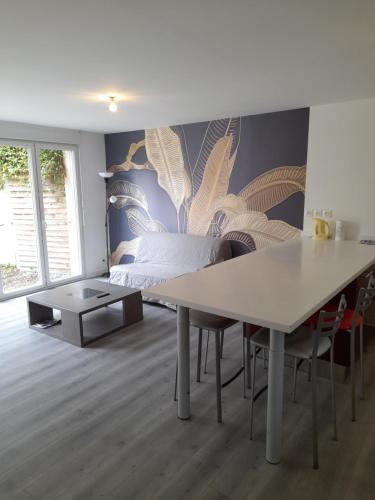 a bedroom with a bed and a table with chairs at Appartements Lannion proche centre, Côtes de Granit Rose in Lannion