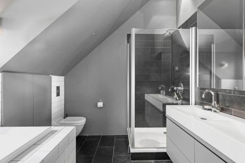 uma casa de banho com um chuveiro, um WC e um lavatório. em Entire house in a quite area em Reiquiavique