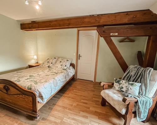 ein Schlafzimmer mit einem Bett und einem Stuhl in der Unterkunft Le Clos de Vitermont in Englebelmer