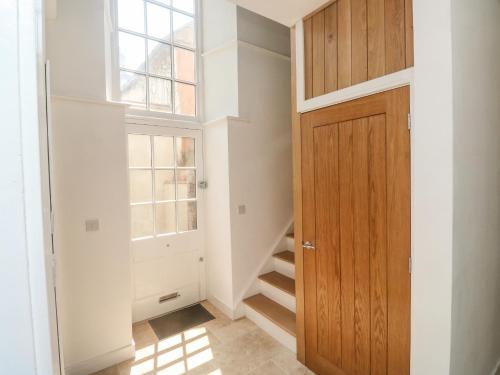 a hallway with a wooden door and a staircase at Chapel House in Okehampton