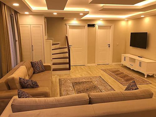 uma sala de estar com um sofá e uma televisão em Garden House Uzungöl em Uzungol