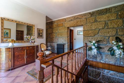 eine Steinmauer in Aoyer mit einer Treppe und einem Spiegel in der Unterkunft Casa do Avô in Entre-os-Rios