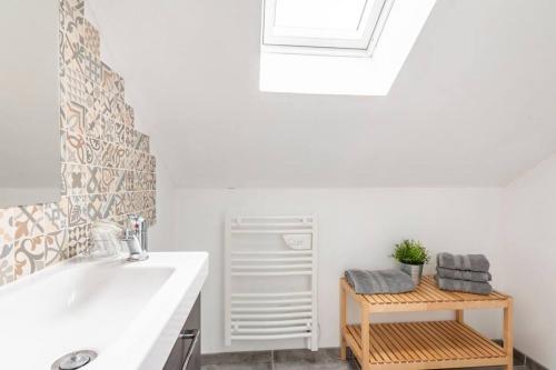 La salle de bains est pourvue d'un lavabo, d'un miroir et d'une table. dans l'établissement La grange de Merlin, à Concoret