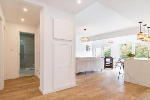 eine Küche und ein Wohnzimmer mit weißen Wänden und Holzböden in der Unterkunft Oeiras Apartment in Oeiras