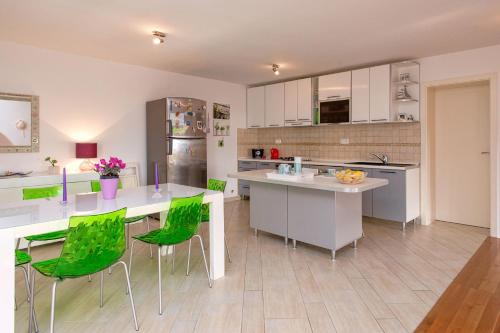 赫瓦爾的住宿－Apartment Duda，厨房配有绿色椅子和厨房岛