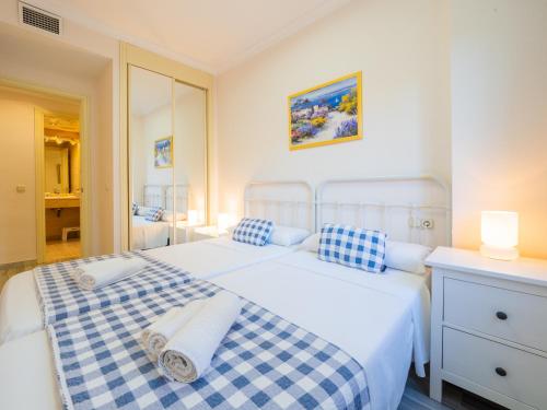 a bedroom with two beds with blue and white pillows at Cubo's Apartamento Nagueles Marbella B5 1E in Marbella