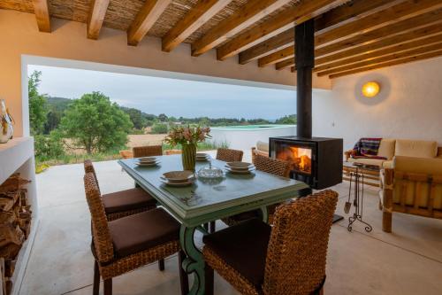 a dining room with a fireplace and a table and chairs at Monte Esmeralda in São Luis