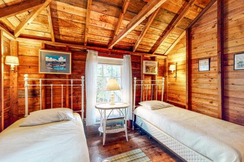two beds in a room with wooden walls at Rockhaven Bay Bliss in East Harpswell