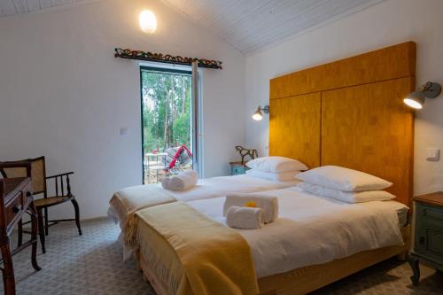 a bedroom with two beds and a desk and a window at Monte Esmeralda in São Luis