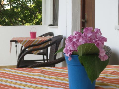 a blue vase with purple flowers sitting on a table at Panagiotis Apostoloudias Rooms in Therma