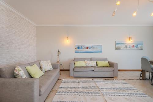 a living room with two couches and a rug at Sea Lux Ericeira in Ericeira
