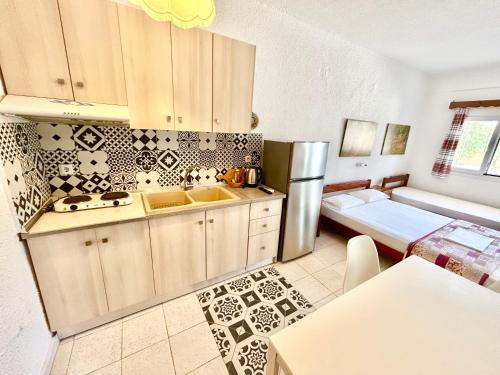 a kitchen with a sink and a refrigerator at Afitos Villa Kristy in Afitos