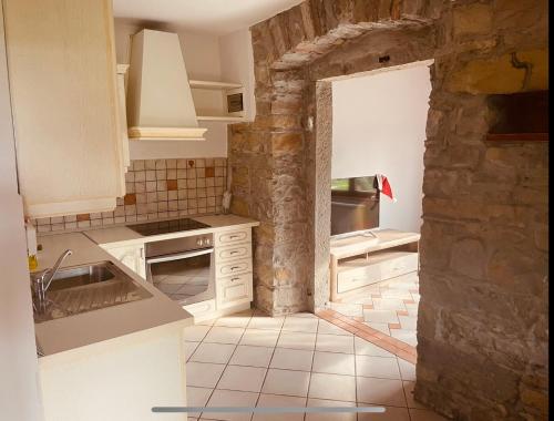 a kitchen with white appliances and a stone wall at Paradise villa with private swimming pool in Koper