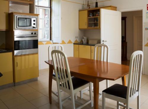 een keuken met een houten tafel en stoelen bij Quinta das Regadinhas in Cinfães