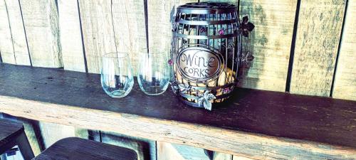 a can and two glasses on a wooden table at Hocking Hills Rusty Lofts in Logan